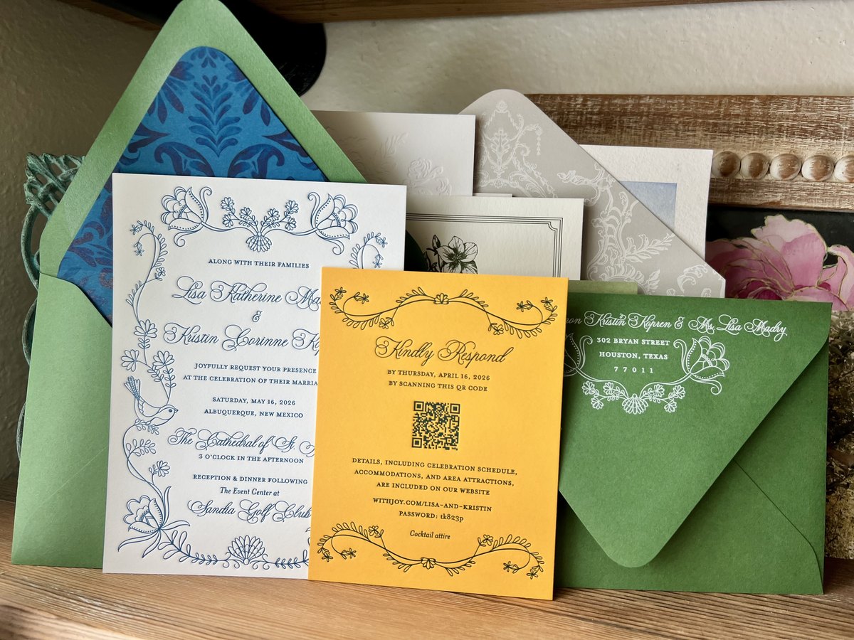 Letterpress wedding invitation in dusty blue line art with doves and wildflowers, with green and blue patterned envelopes, image 1 of 3
